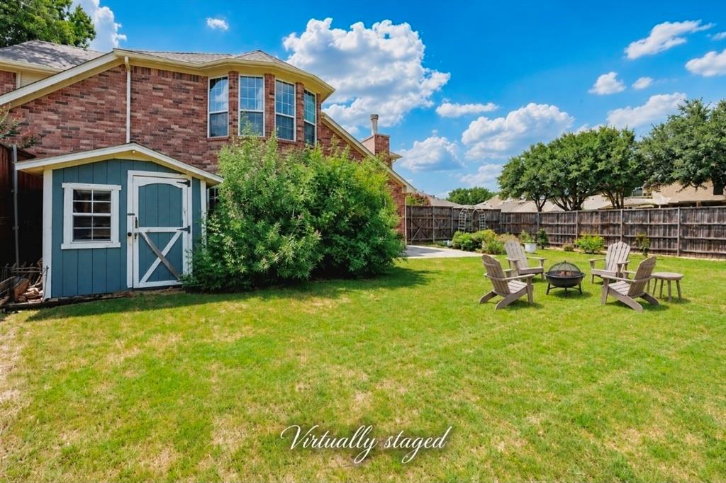 Backyard featuring a brick-exterior residence, a detached storage shed, a concrete patio, and a wood privacy fence