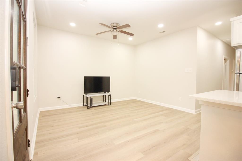 Neutral-toned interior featuring wood-finish flooring, recessed lighting, a ceiling fan, and a wood-paneled door with glass inserts