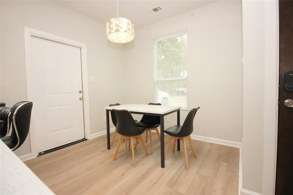 Wood-finish flooring, neutral wall tones, decorative drum pendant lighting, and a single vertical window