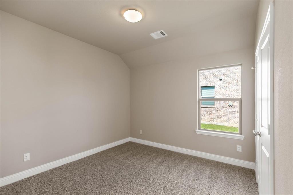 Neutral-toned interior space featuring carpeting, a flush-mount ceiling light fixture, and a single-pane window with a white frame
