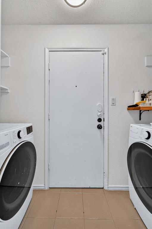 Laundry area featuring neutral tile flooring, built-in wall shelving, and a solid-core exterior door