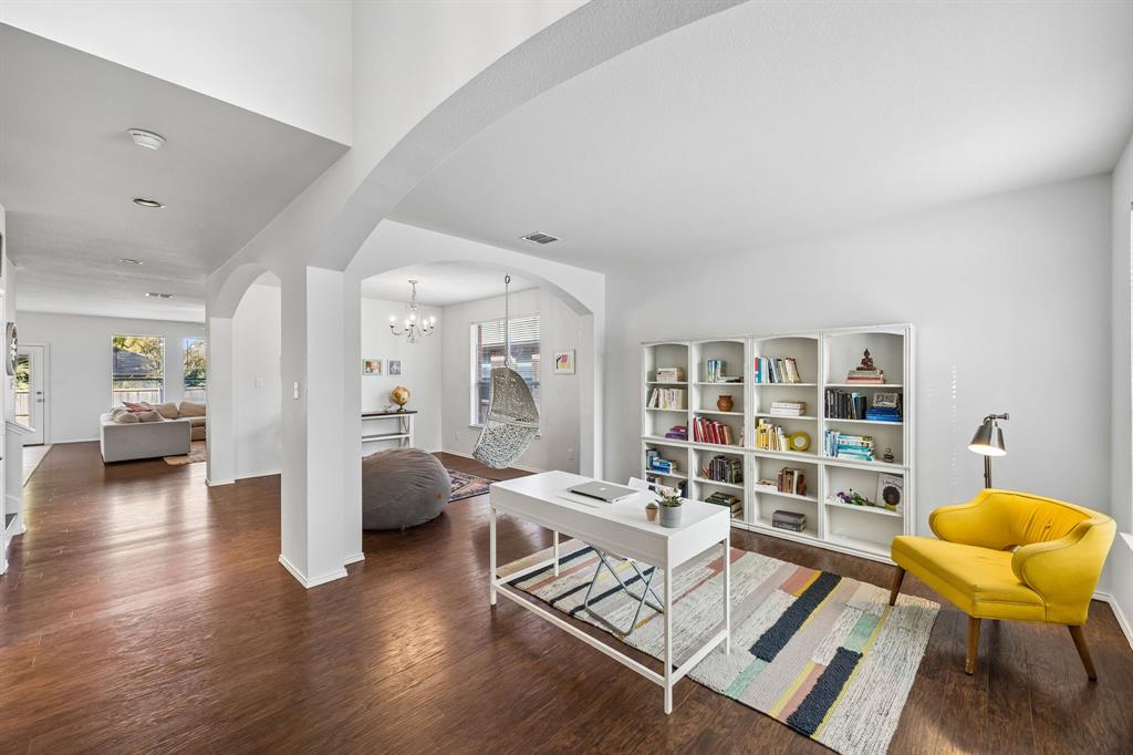 Elegant architectural arches define this versatile living area, offering a beautiful balance of openness and distinction. Warm wood-look flooring extends throughout, while the expansive layout accommodates a stylish home office, formal sitting area, or additional gathering space tailored to your lifestyle.