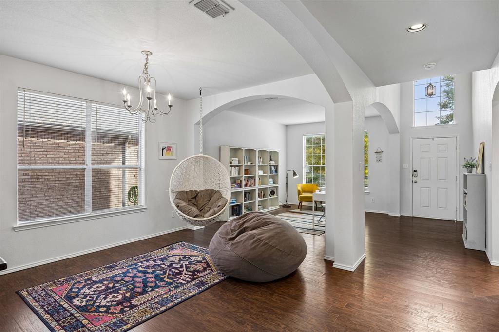 An appealing blend of architectural character and open design welcomes you into this light-filled interior. Arched passageways create visual interest while connecting the living spaces, and warm wood-look flooring flows throughout. A soaring two-story entry with an upper window draws in natural light and enhances the home's impressive sense of arrival.