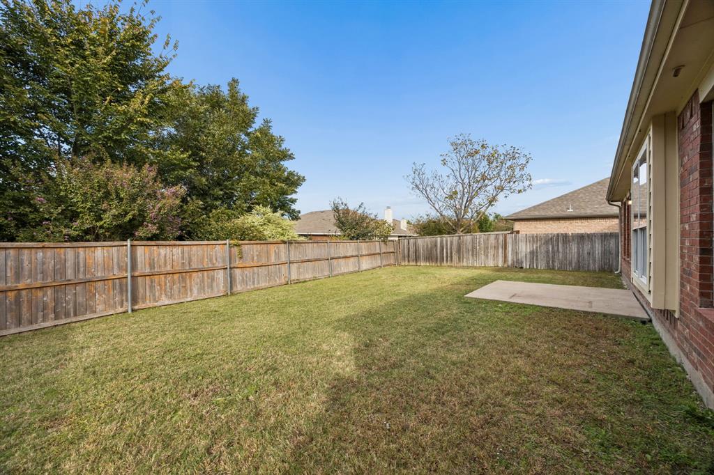 Enjoy the privacy and flexibility of this fenced backyard, featuring an expansive grassy lawn and a concrete patio conveniently located just outside the home. Mature trees and established landscaping beyond the fence add a pleasant natural backdrop, while the open yard provides space for outdoor enjoyment, gardening, or future landscaping enhancements.
