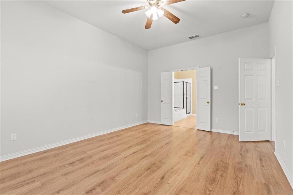 High-vaulted ceilings featuring a central wood-finish ceiling fan, wood-finish flooring, and double-door entry
