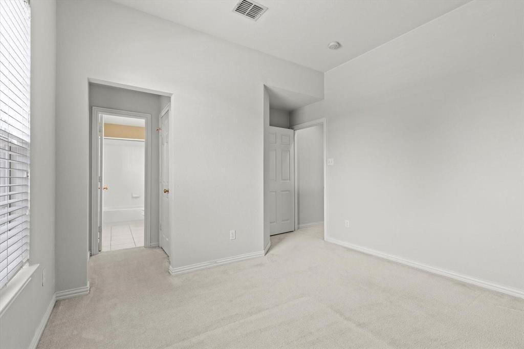 Room featuring neutral wall tones, high ceilings, carpeted flooring, and white paneled interior doors