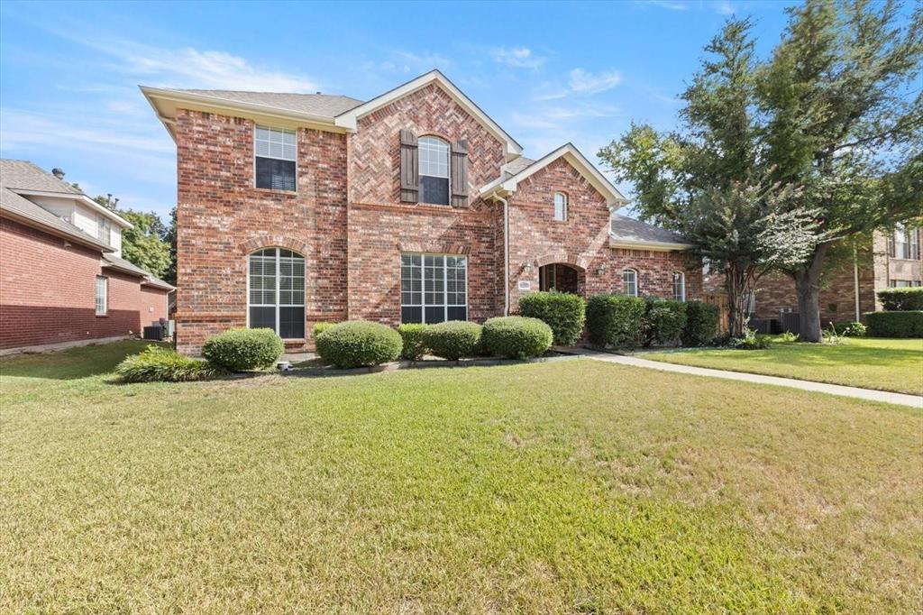 Traditional brick exterior featuring a multi-gabled roofline, decorative herringbone brickwork details, arched window frames, and manicured shrubbery Traditional brick exterior featuring a multi-gabled roofline, decorative herringbone brickwork details, arched window frames, and manicured shrubbery