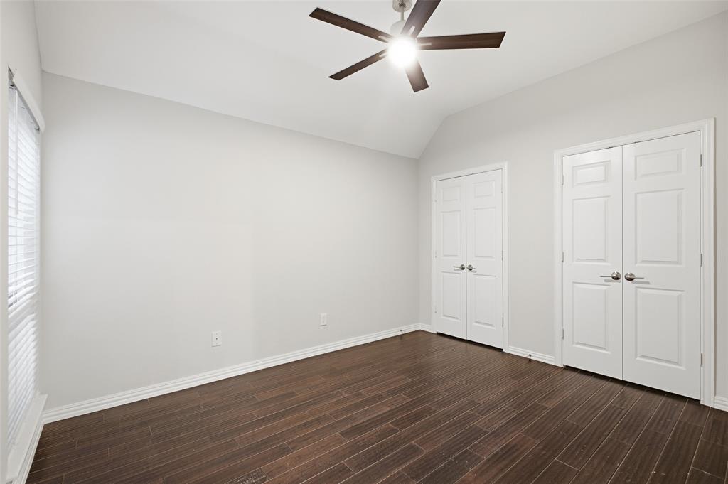 This spacious secondary bedroom has a vaulted ceiling and two double-door closets for abundant storage.