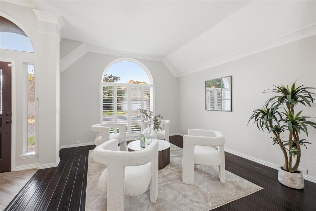 Vaulted ceilings, crown molding and an arched window with plantation shutters make the front sitting room an elegant spot for morning coffee or quiet reading.
