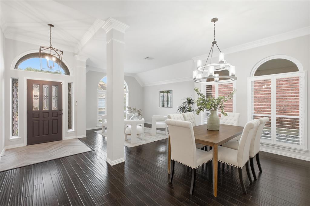 Arched transom, leaded-glass front door and a lantern pendant welcome you into a light-filled foyer that opens to the formal dining room.