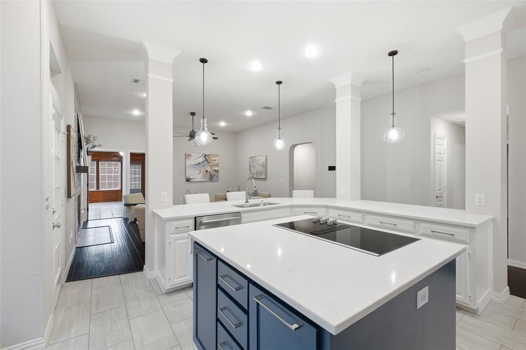The navy center island adds a sleek cooktop and extra prep space, keeping the cook part of the conversation.