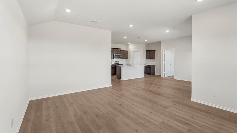 Wood-finish flooring throughout, recessed lighting, and white walls