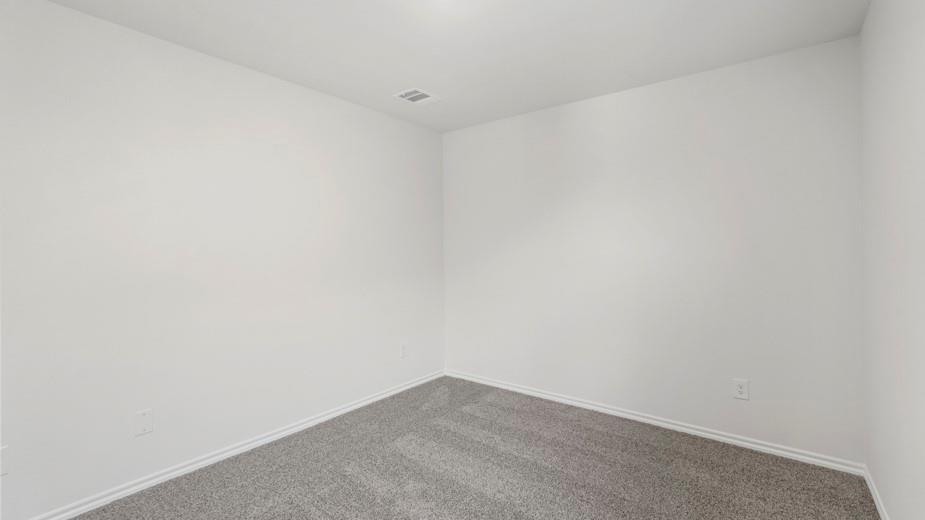 Recessed ceiling light with a flush-mounted register, light gray wall-to-wall carpeting, and white painted walls