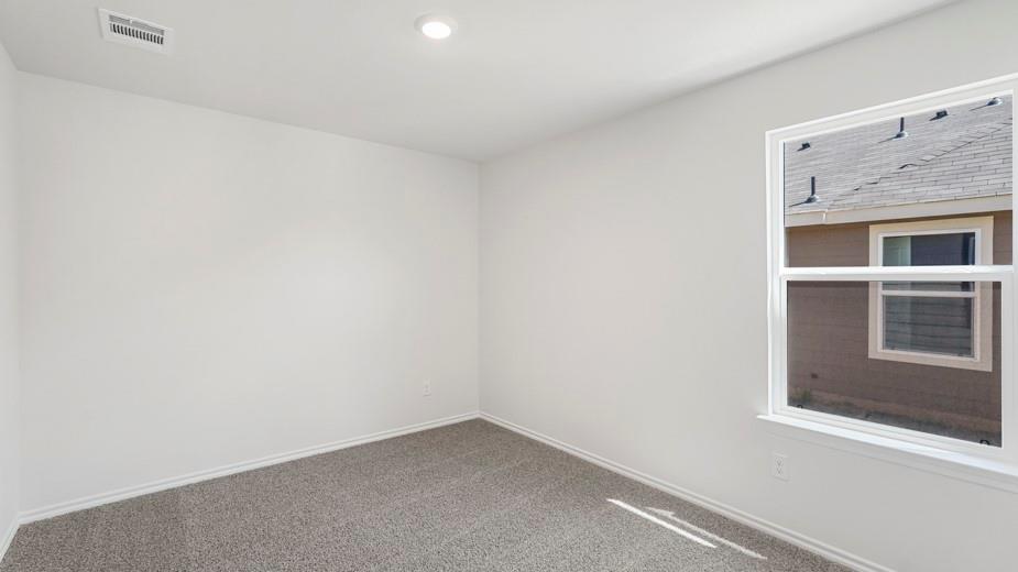 Recessed ceiling lighting, large window, neutral wall paint, and gray carpet
