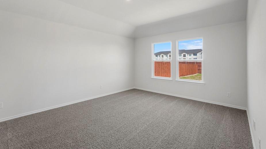 Recessed ceiling light, vaulted ceiling, two windows, gray carpet flooring, white walls