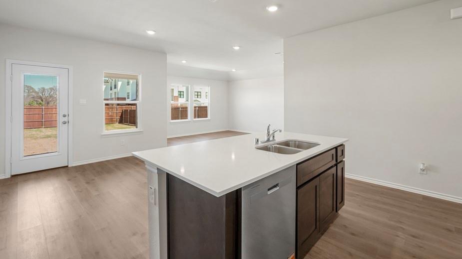 Kitchen island with white countertop, integrated double-basin sink, and dishwasher