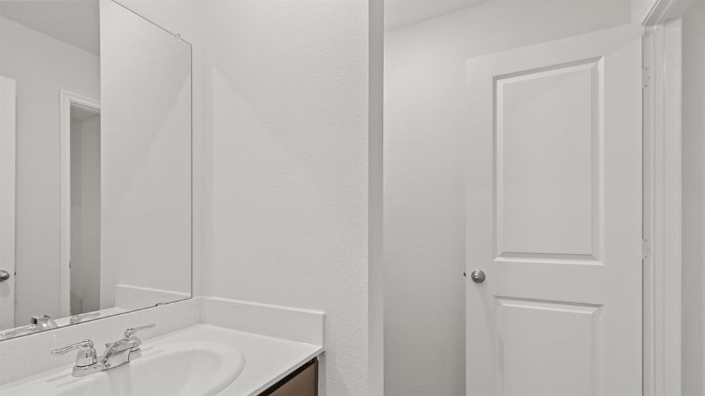 Vanity area featuring a rectangular undermount sink, chrome faucet, and expansive wall-mounted mirror