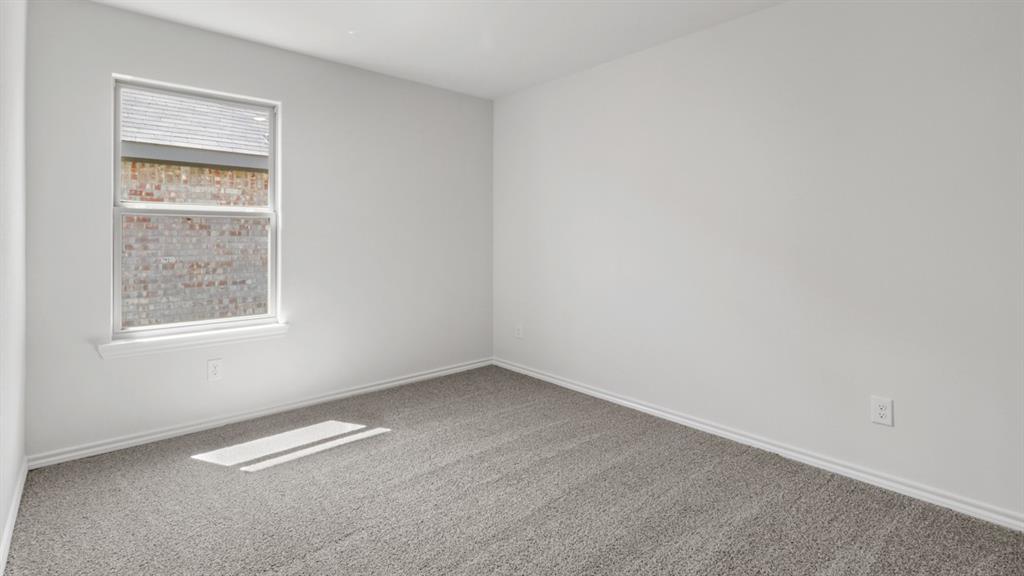 Interior room featuring light gray carpet flooring, white painted walls, and white baseboards