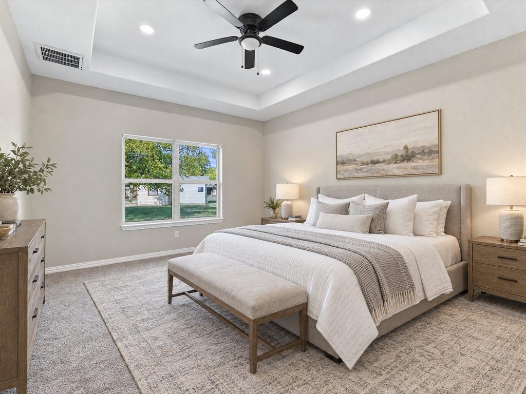 Virtually Staged Primary Bedroom featuring tray ceiling with recessed lighting and a central matte black ceiling fan, complemented by carpeting and a dual-pane window