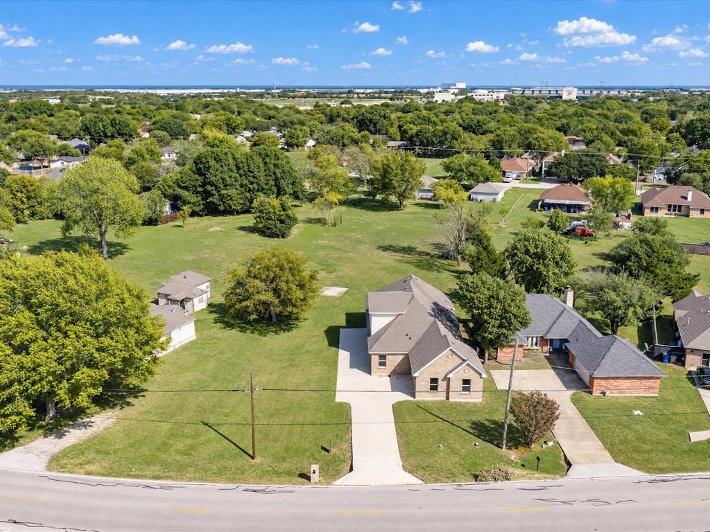 Expansive parcel featuring a brick exterior residence, concrete driveway, and abundant mature trees