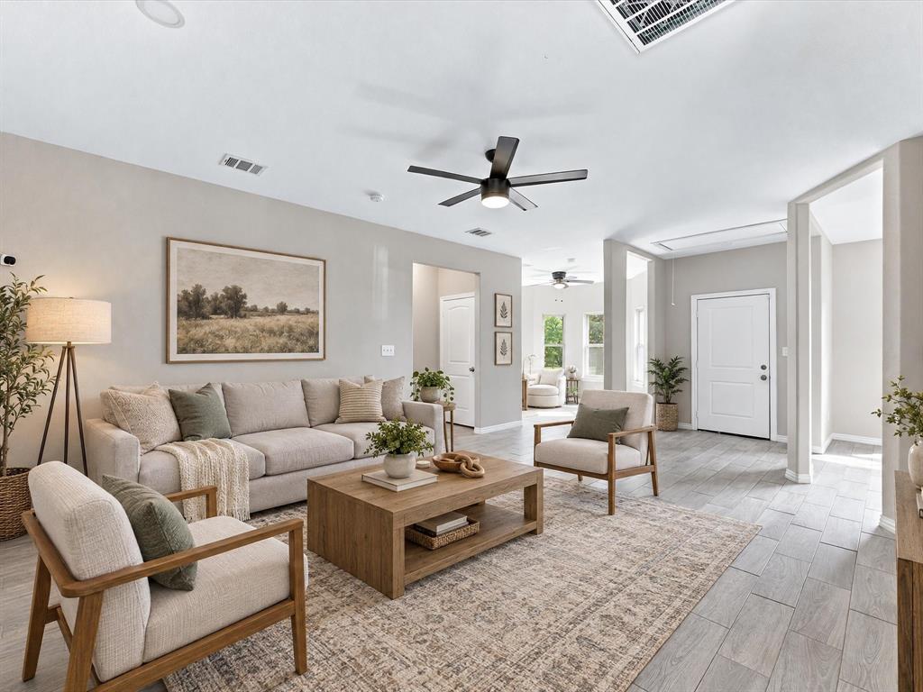 Virtually staged open-concept interior featuring light-toned wood-finish flooring, recessed lighting, neutral wall paint, and a modern ceiling fan