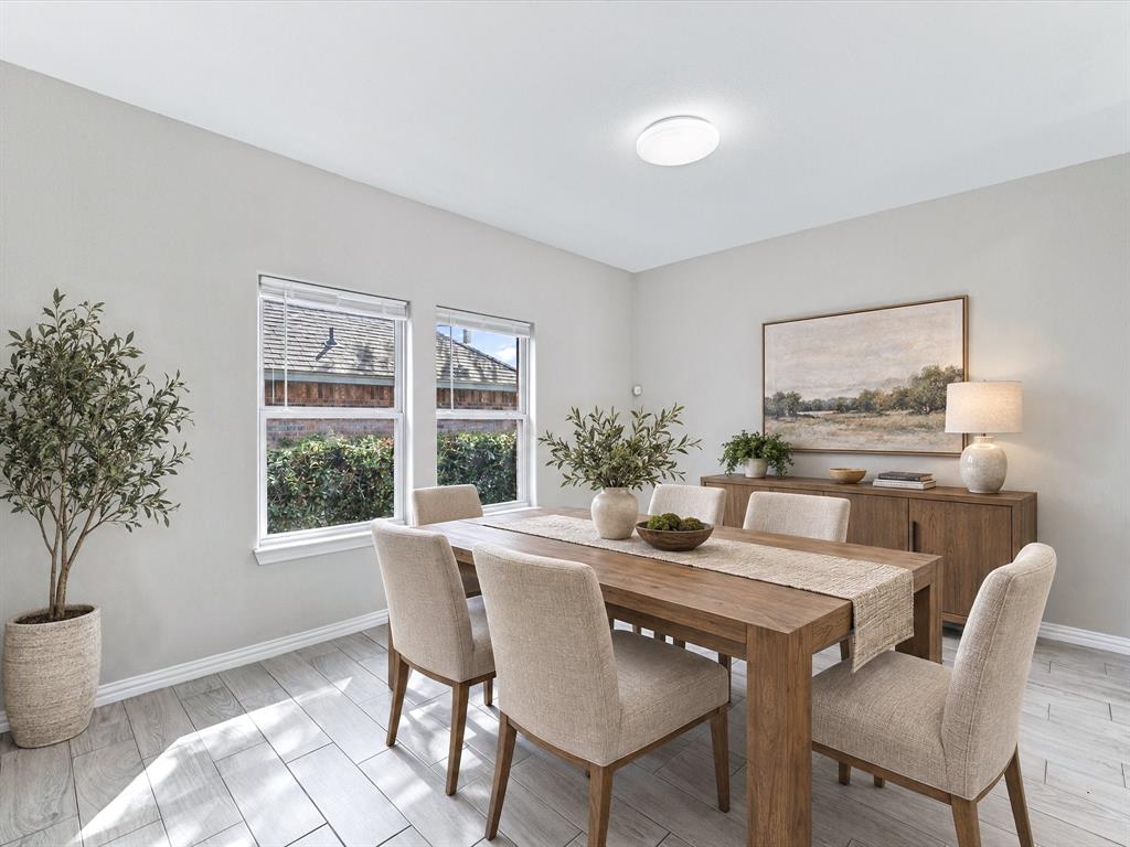 Virtually Staged Dining Area with neutral-toned walls, wood-finish tile flooring, and dual double-pane windows with integrated blinds