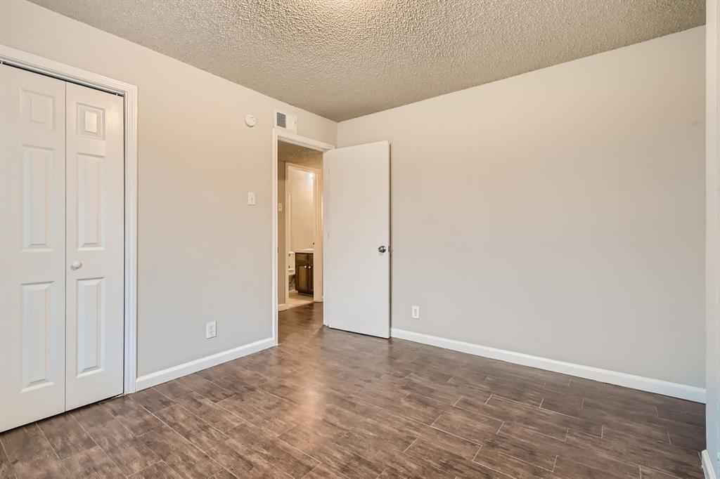 Interior space featuring wood-finish tile flooring, a dual-panel bi-fold closet door, and neutral wall tones