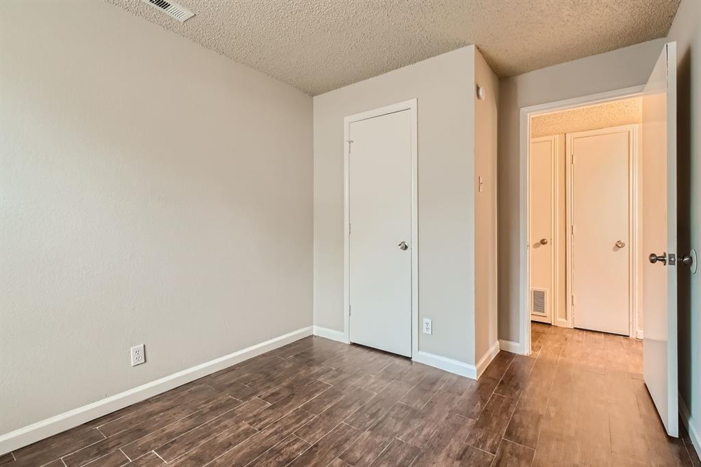 Interior space featuring neutral wall paint, wood-finish flooring, and multiple solid-core doors