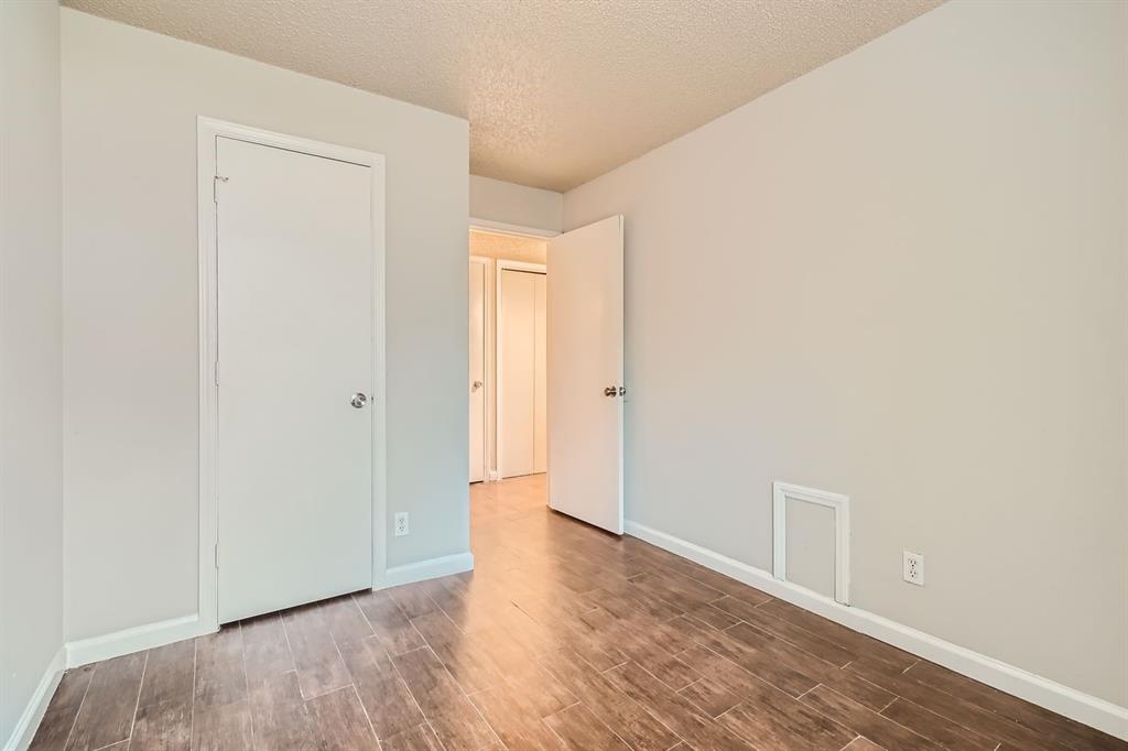 Neutral-toned interior space featuring wood-finish tile flooring and interior swing doors