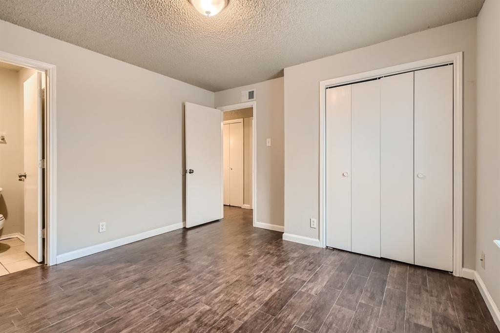 Neutral-toned interior space featuring wood-finish flooring, a bi-fold closet, and ceiling-mounted light fixture