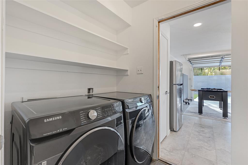 Laundry area featuring built-in shelving and dual front-load laundry appliances