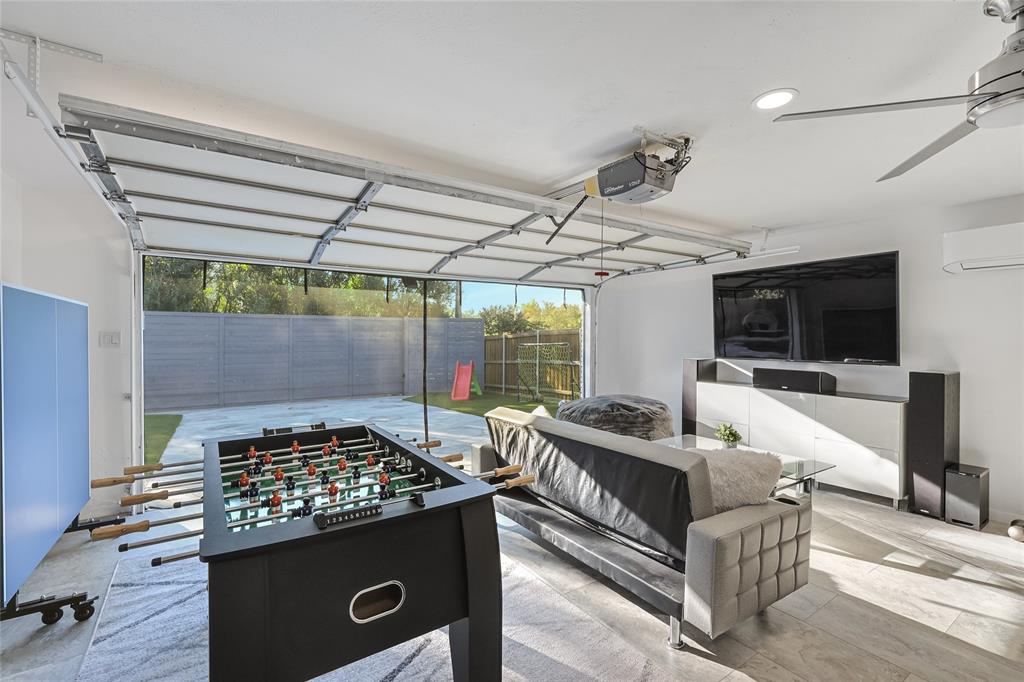 Garage space featuring tile flooring, a wall-mounted mini-split HVAC unit, recessed lighting, and a ceiling fan