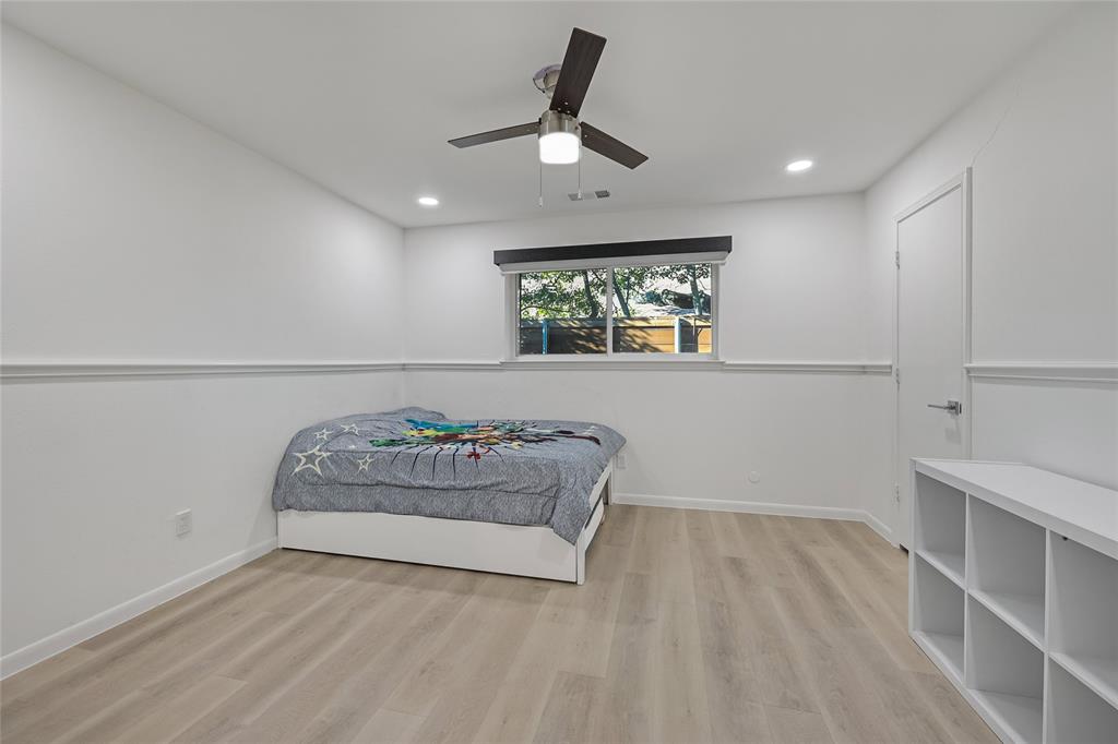 Interior room featuring wood-finish flooring, white chair rail molding, recessed lighting, and a three-blade ceiling fan with integrated lighting