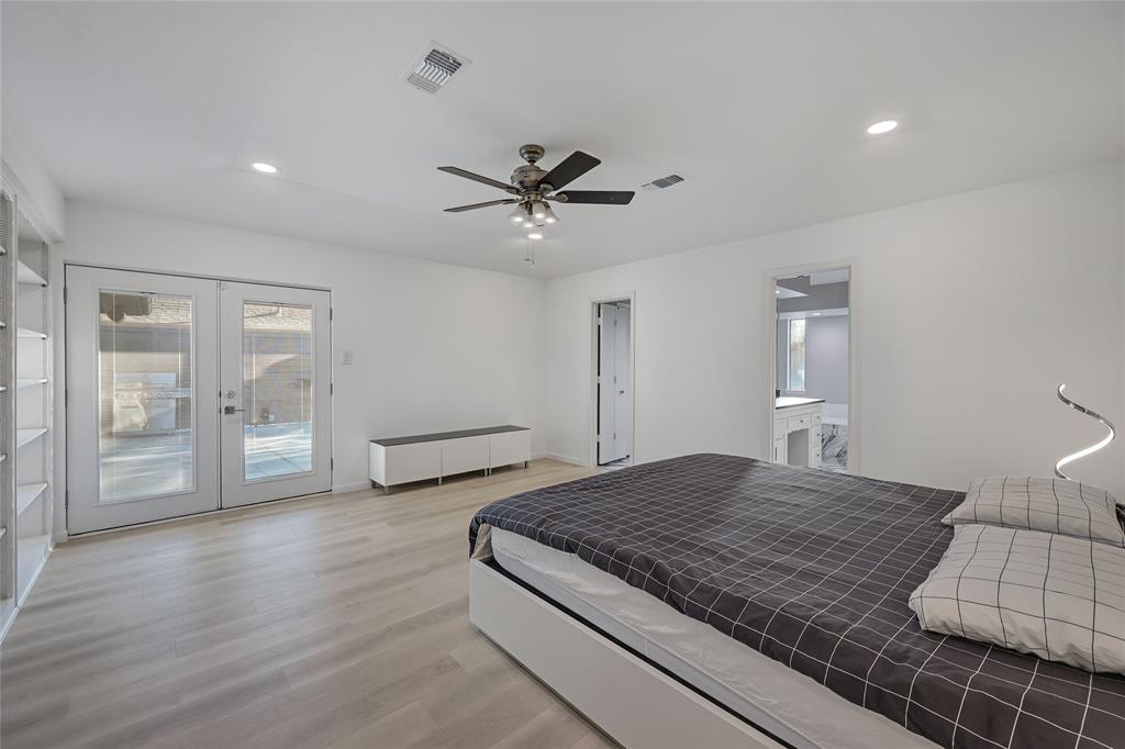 Interior space featuring light wood-finish flooring, recessed lighting, a ceiling fan with integrated light kit, built-in shelving, and white-framed glass French doors