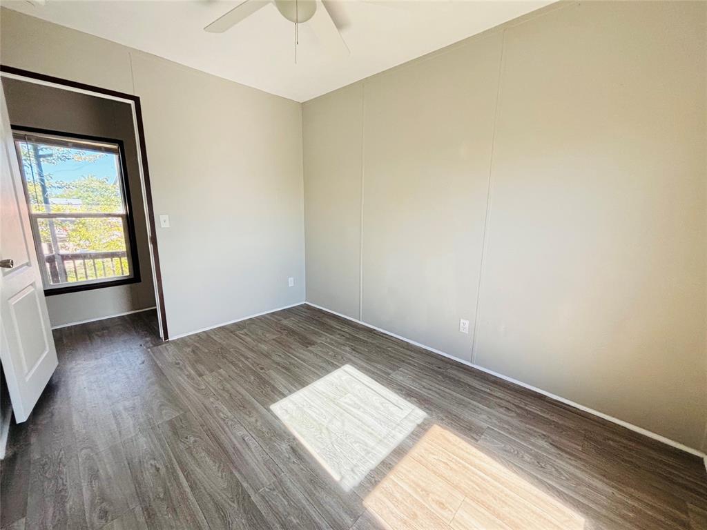 Neutral-toned walls, wood-finish flooring, and a ceiling-mounted fan