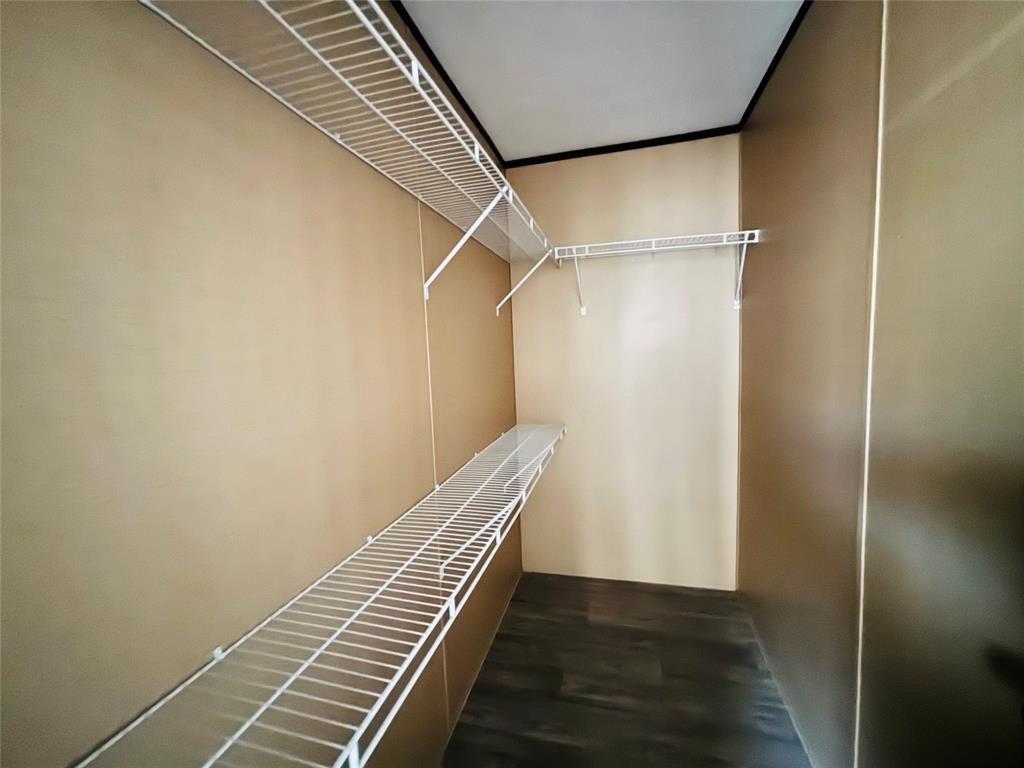 Storage space featuring white wire shelving and wood-finish flooring