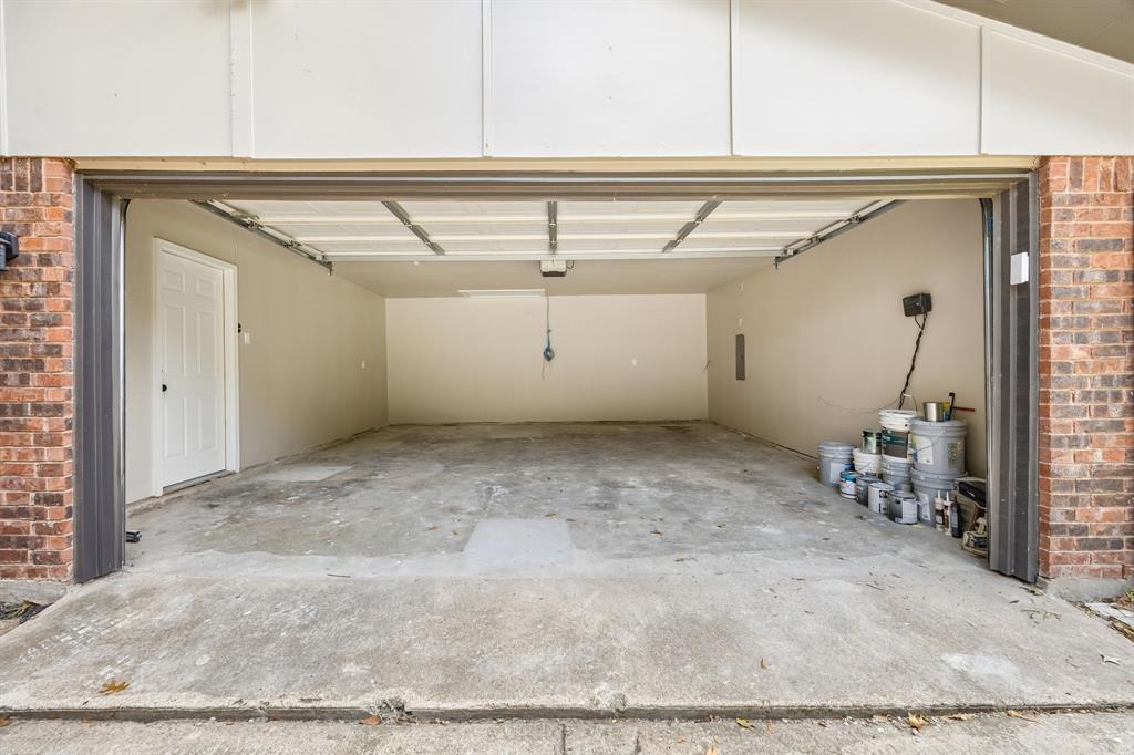 An expansive garage offers abundant room for vehicle parking, storage, and workspace possibilities. The wide garage opening provides convenient access, while the durable concrete floor and dedicated side entry add everyday functionality. With generous interior space and room to organize equipment or seasonal belongings, this area offers versatility beyond traditional parking.