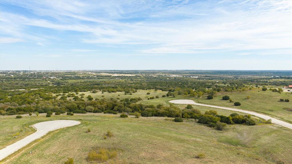 Expansive unimproved acreage featuring rolling topography, native vegetation, and paved cul-de-sac access
