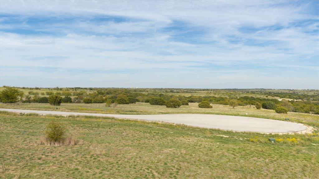 Expansive acreage featuring native grasslands, mature trees, and a paved cul-de-sac