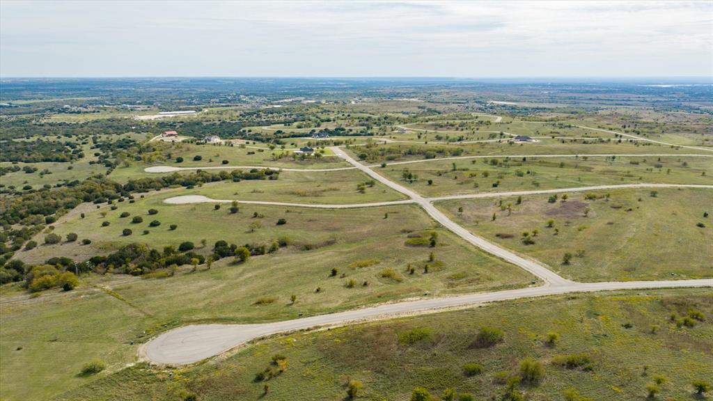 Aerial perspective of expansive acreage featuring paved cul-de-sacs, rolling topography, and native vegetation