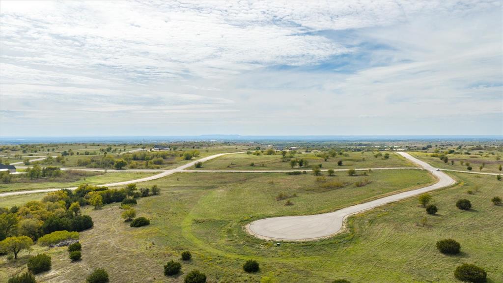 Expansive vacant land featuring rolling terrain, paved cul-de-sac access, and mature trees