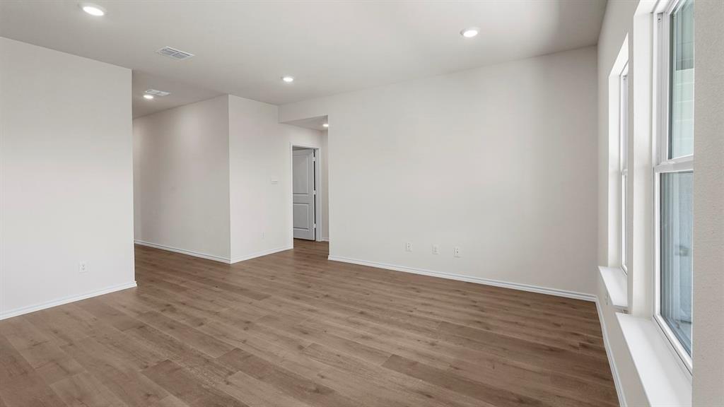 Interior space featuring neutral wall paint, wood-finish flooring, recessed lighting, and multi-pane windows