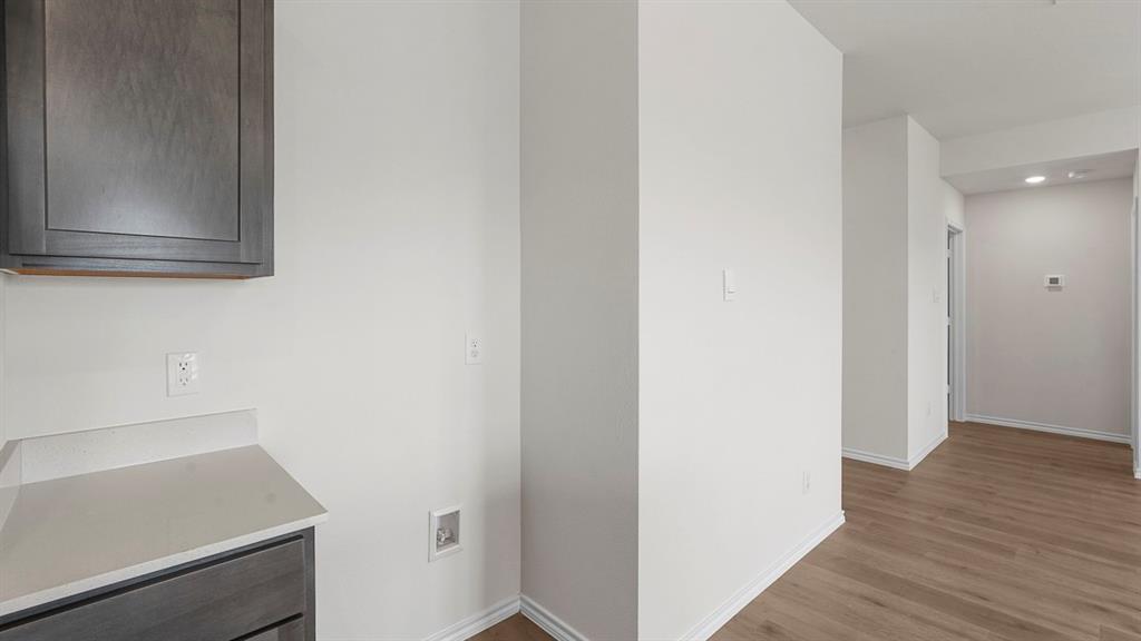 Built-in cabinetry with wood-finish doors, solid-surface countertop, and wood-finish flooring
