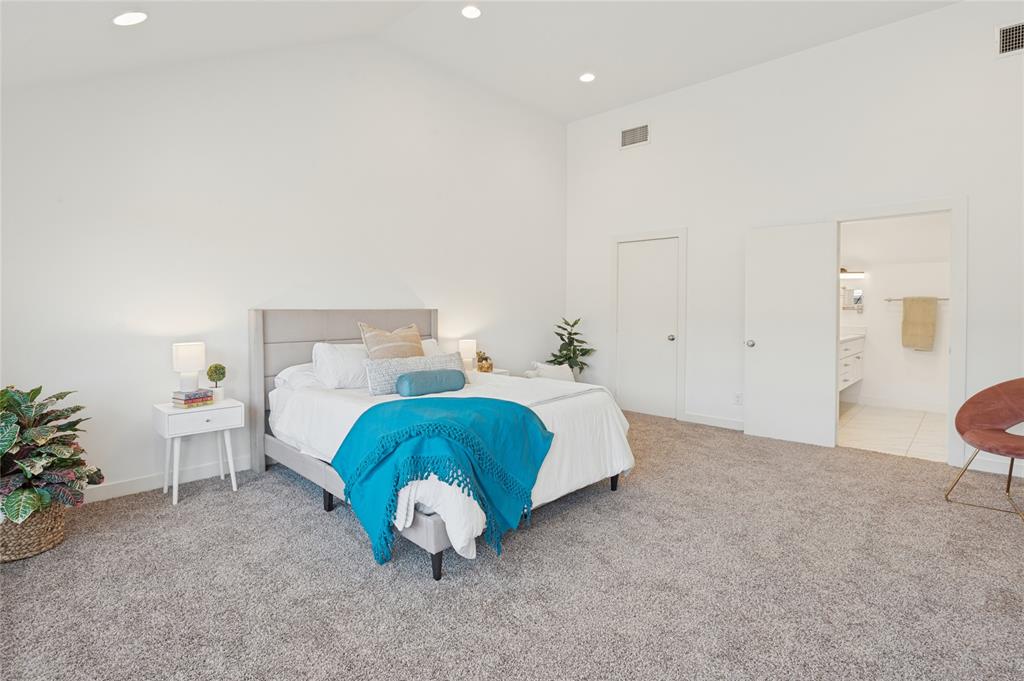 Vaulted ceilings, neutral carpeting, and recessed lighting