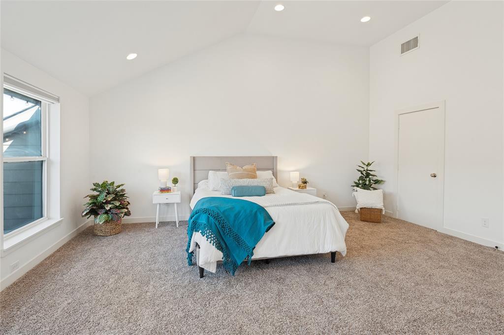 Vaulted ceilings, neutral carpeting, recessed lighting, and large windows