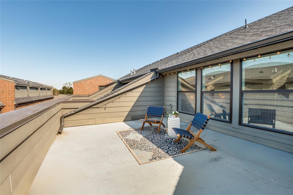 Elevated terrace featuring horizontal siding, expansive windows, and a metal railing