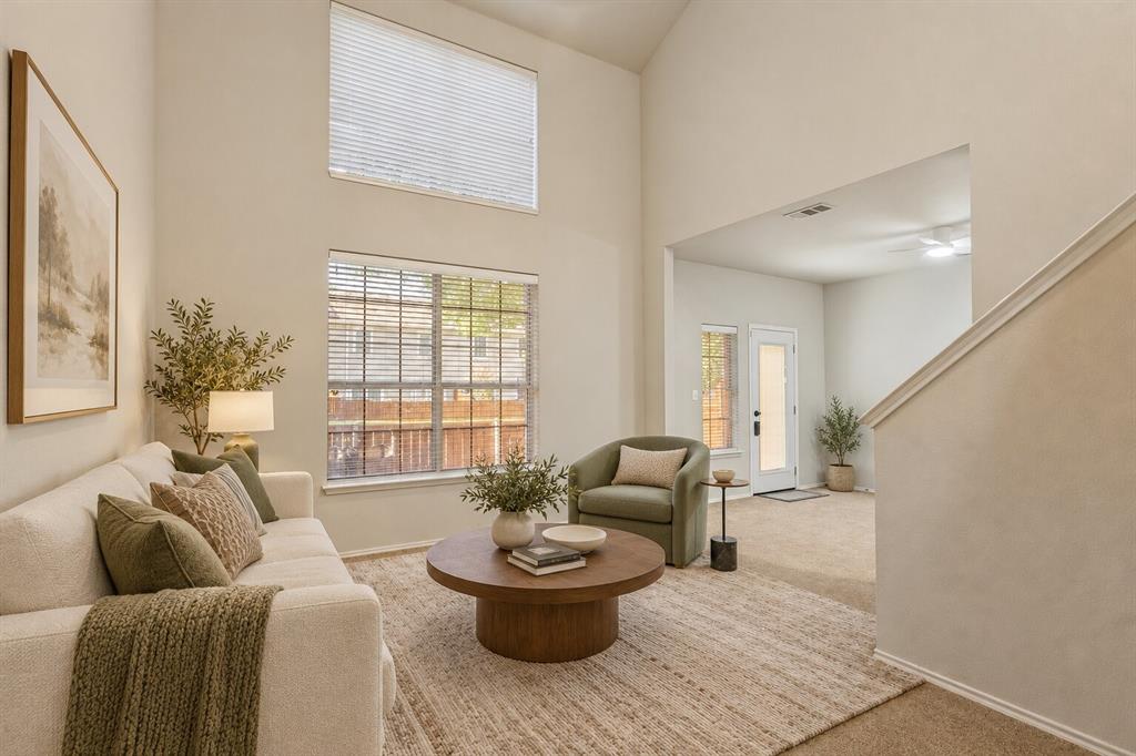 Vaulted ceilings, expansive stacked windows, neutral wall palette, and carpeted flooring