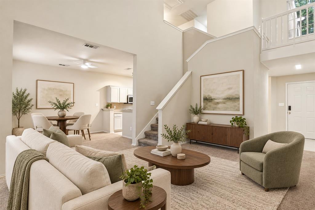 Vaulted ceilings, open-concept floor plan, second-story landing with balcony railing, and carpeted staircase