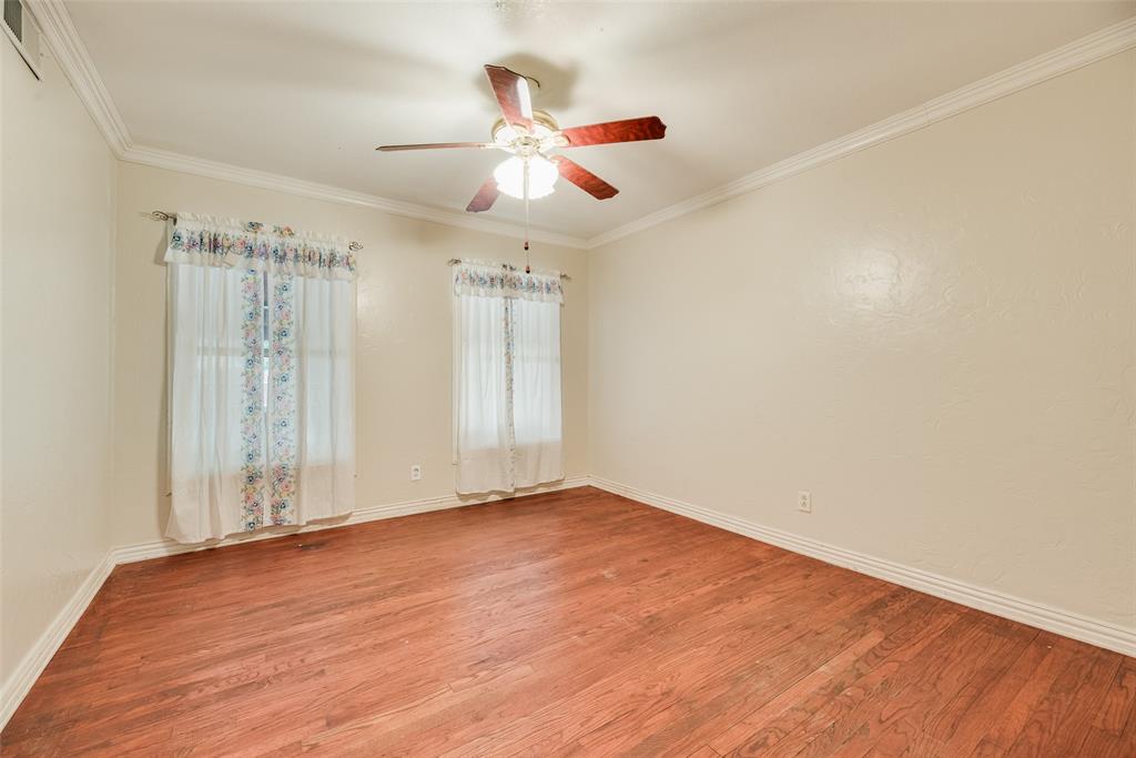 Interior room featuring wood-finish flooring, crown molding, and a central ceiling fan with integrated light fixture