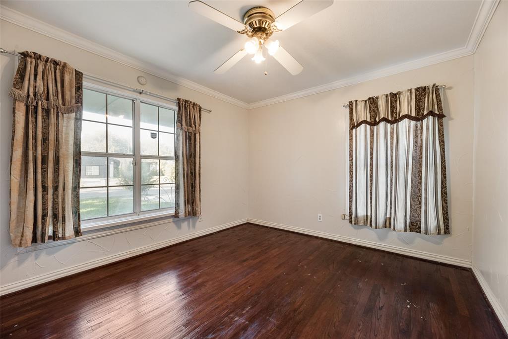 Room featuring wood-finish flooring, crown molding, multi-pane windows, and a ceiling fan with integrated lighting
